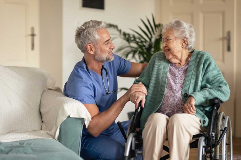 A family spending time with a senior loved one during a group craft activity in a bright, cheerful common room.